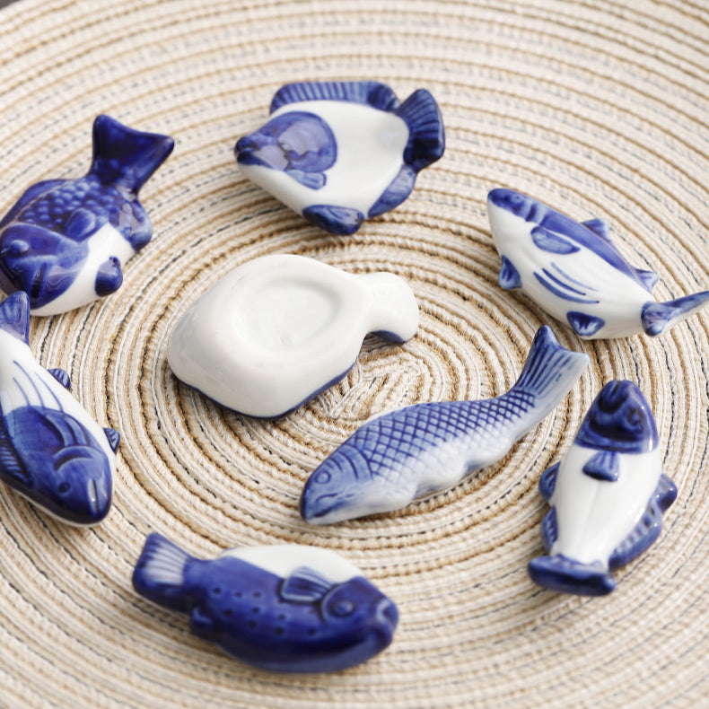 Set of ceramic fish figurines on a woven mat with text in the background