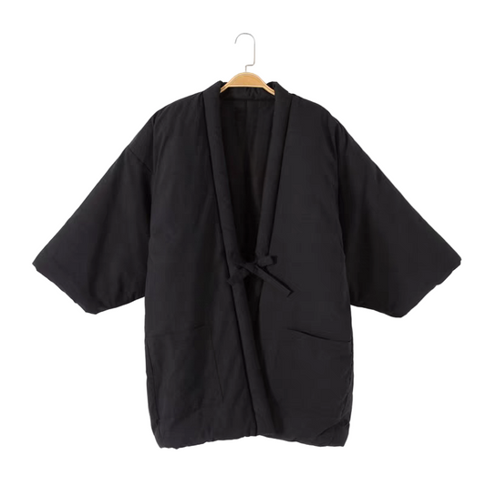 Black kimono-style garment on a hanger against a white background