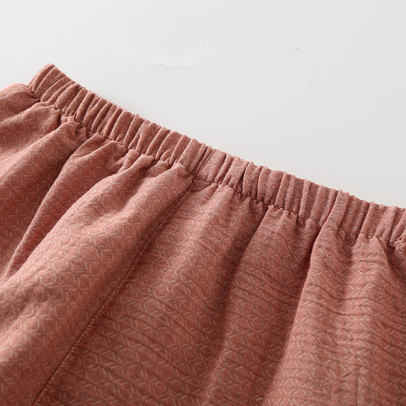Close-up of pink textured pants on a light gray background