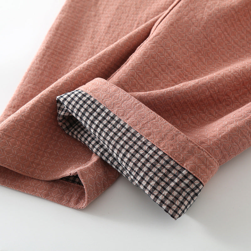 Close-up of pink fabric with a checkered edge on a white background