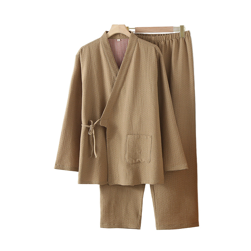Brown robe and pants set on a hanger against a white wall 