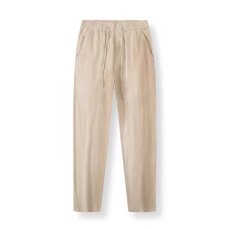 A pair of beige linen trousers with an elastic waistband and drawstring, displayed flat against a white background.