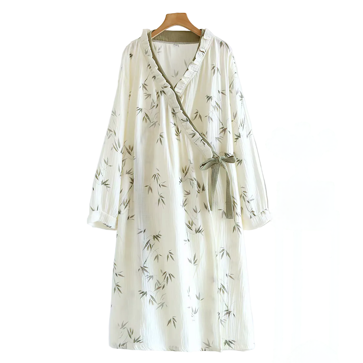 A long-sleeve wrap-style dress in off-white with a delicate green bamboo print, hanging on a wooden hanger against a plain white background.
