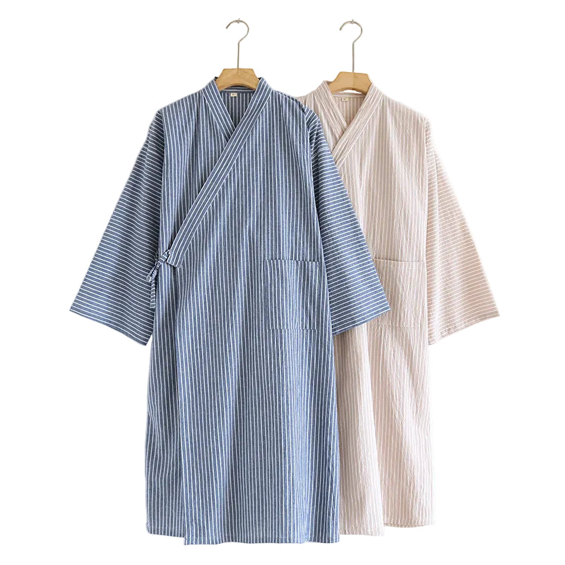 Two lightweight wrap robes hanging on wooden hangers against a plain white wall. The front robe is blue with thin white vertical stripes, and the back robe is a solid light beige with a subtle vertical texture.