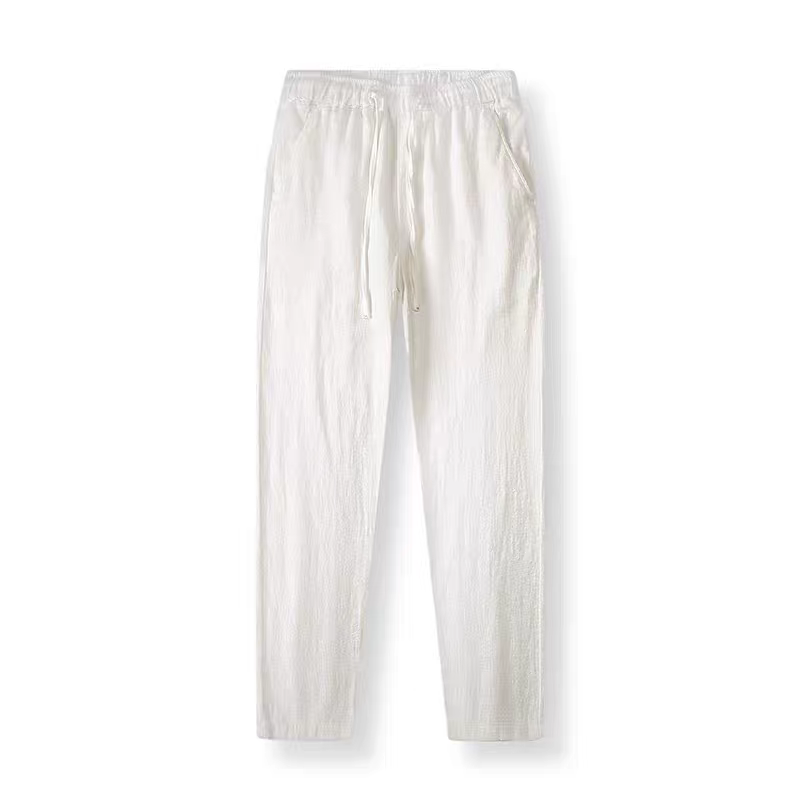 A pair of off-white linen pants with an elastic waistband and drawstring, displayed flat against a white background.