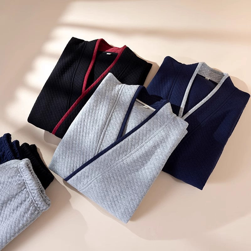 Folded clothing items in black, blue, and gray on a light beige background