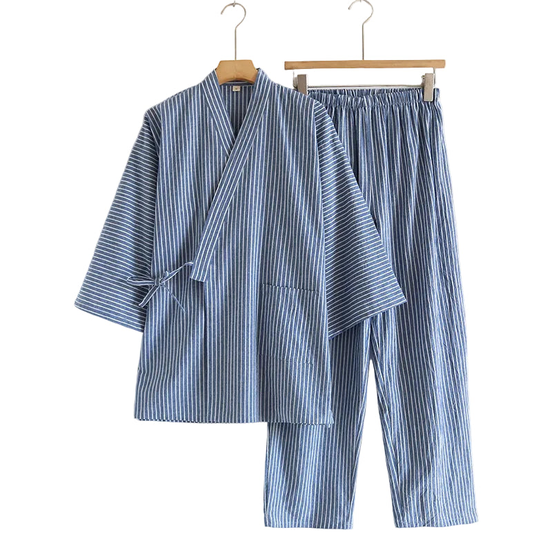 Blue and white striped pajama set hanging on wooden hangers against a white background